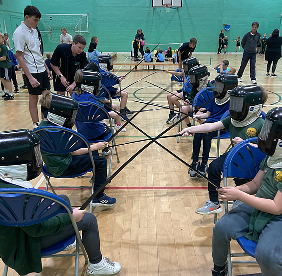 Children practising fencing in a sports hall